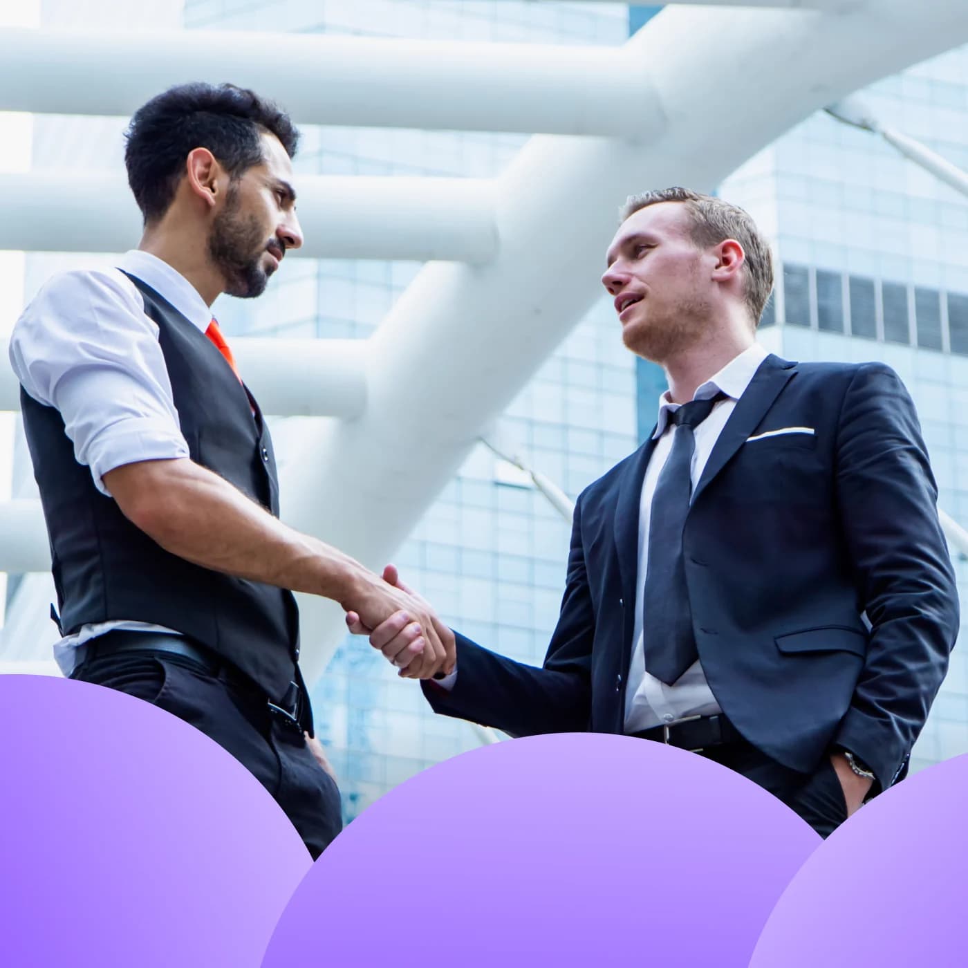 Businessmen shaking hands against a modern building